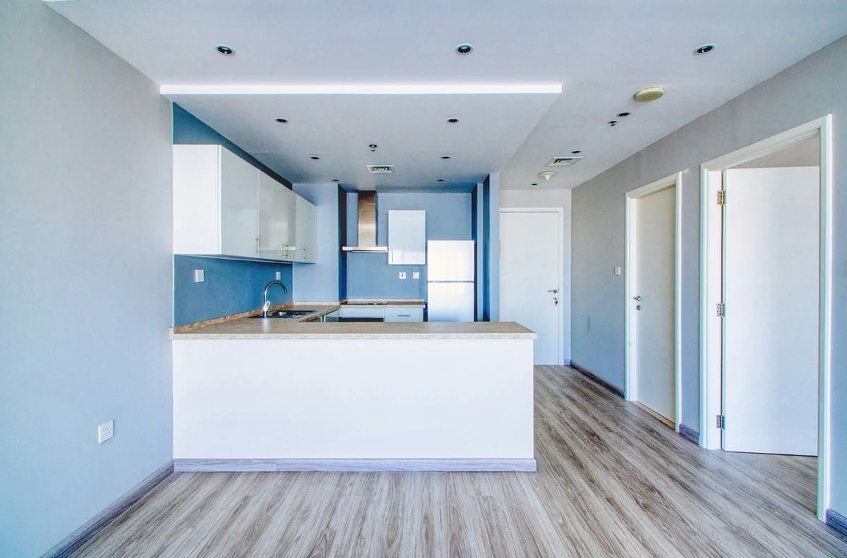 A modern kitchen and living space are shown