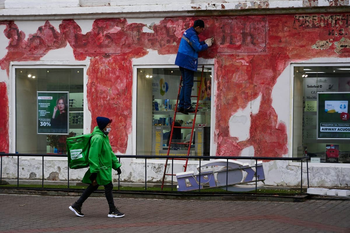a man in a green jacket is climbing a ladder